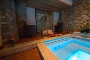 una piscina in una stanza con un muro in pietra di Villa Lecchi Hotel Wellness a Colle Val D'Elsa