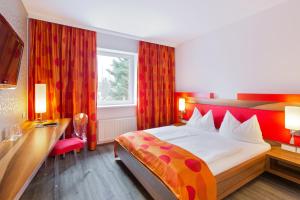 バーデンにあるMotel Badenの大きなベッドとデスクが備わるホテルルームです。