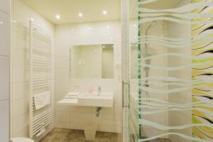 a white bathroom with a sink and a mirror at Motel Baden in Baden +19 photos