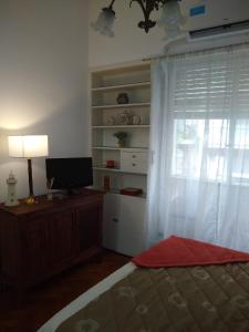 a bedroom with a bed and a television and a window at DTO 1AMB. RECOLETA in Buenos Aires