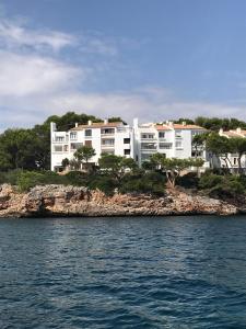 un grande edificio bianco su un'isola in acqua di Appartement Ferrera Park vue mer a Cala Ferrera