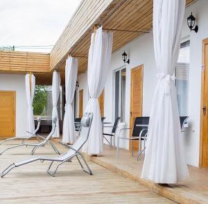 a room with white curtains and chairs and tables at Hotel 7 in Kapchagay