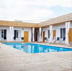 a swimming pool in front of a building with chairs at Hotel 7 in Kapchagay