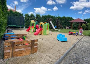 un parque infantil con arenero y equipo de juegos en Pandora Apartmanok, en Hajdúszoboszló
