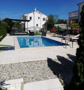 a swimming pool in front of a house at Apartments Jankovic in Vodice