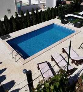 une piscine avec deux chaises et une table dans l'établissement Apartments Jankovic, à Vodice 32 autres photos