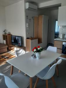 a white table and chairs with a vase of flowers on it at Vala Mar apartment- A41 in Durrës