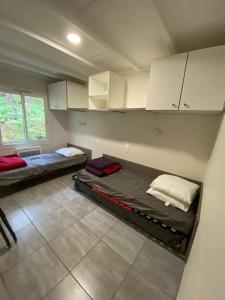 Cette chambre comprend 2 lits et des armoires blanches. dans l'établissement LES COTTAGES DE LEON, à Léon 83 autres photos