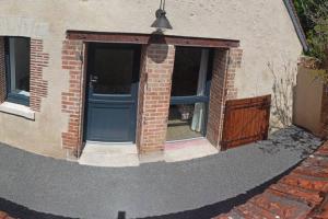 a brick building with a blue door and a window at Gîte Le Tico in Cheverny