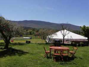 a table and chairs in a field with a tent at El Mirador del Gato I y II in Mesegar de Corneja