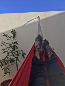 a person sitting in a hammock with their feet on it at Casa da Madrinha in Vila do Bispo