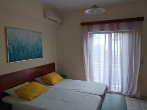 a bedroom with two twin beds and a window at Pension Irene in Sougia