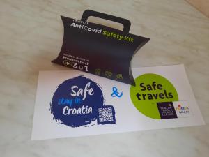 a box of safe travels and two stickers on a table at Apartments & rooms MIKLEUS in Mošćenička Draga