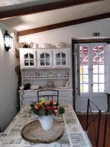 a kitchen with a table with a vase of flowers on it at Casa de Chanca in Penela +57 photos