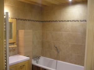 ein Badezimmer mit einer Badewanne und einem Waschbecken in der Unterkunft Chalet la Tuilière***** in Bonneval-sur-Arc