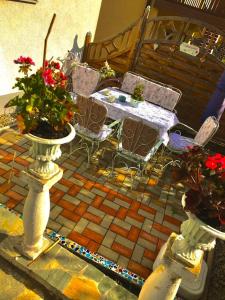 a patio with chairs and a table and flowers in vases at Burgi`s Ferienhaus in Litschau