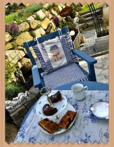 a blue chair with a plate of food on a table at Burgi`s Ferienhaus in Litschau