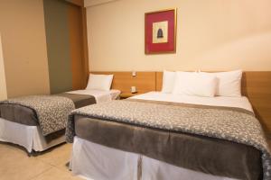 um quarto de hotel com duas camas num quarto em Hotel Porto Real Aparecida em Aparecida