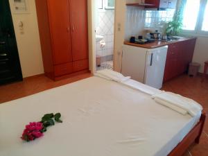 a large white bed in a kitchen with flowers on it at Fantastico Studios #2 in Kalamitsi