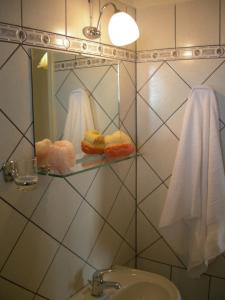 a bathroom with a sink and a mirror with towels at Fantastico Studios #2 in Kalamitsi