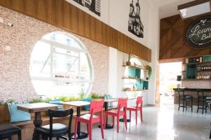 a restaurant with red chairs and tables and a window at Hotel Porto Real Aparecida in Aparecida