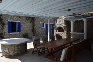 einen Holztisch und Stühle unter einer weißen Pergola in der Unterkunft Villa Irini in Panormos, Mykonos