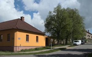 un bâtiment jaune au bord d'une rue dans l'établissement Apartmán Mařenka, à Nové Město na Moravě
