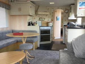uma pequena cozinha com uma mesa e uma mesa e cadeiras em H15 em Aberystwyth