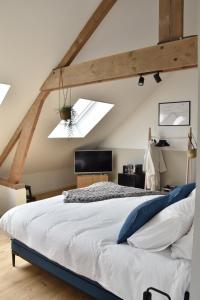 a bedroom with a large white bed and skylights at ZeeLand & Meer in Kamperland