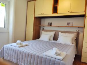 1 dormitorio con 1 cama con 2 toallas en Apartman Marina II, en Rogoznica