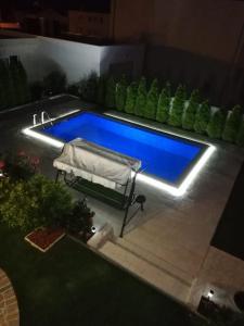 a swimming pool in a backyard at night at Apartments Jankovic in Vodice