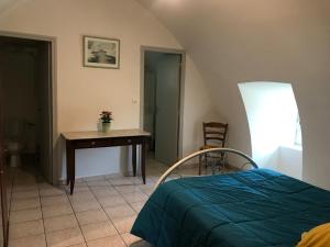 a bedroom with a bed and a table and a desk at Gite Montalies in Novis
