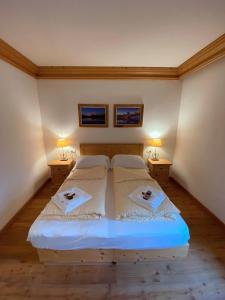 a bedroom with a large bed with two night stands at Rifugio Ospitale in Cortina dʼAmpezzo