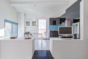a white kitchen with a desk with a computer on it at Opuntia (Pech) location en Méditerranée in Escales
