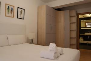 Un dormitorio con una cama blanca con toallas. en AZ El Balcón de Atares, en Zaragoza