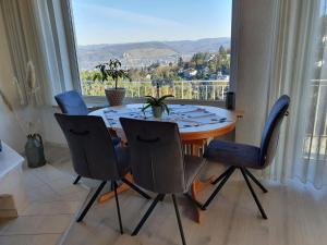 a dining room table with chairs and a large window at Ferienwohnung Schlossblick Bad Breisig in Bad Breisig