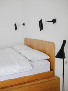 łóżko z 2 białymi poduszkami i czarną lampą w obiekcie Mariinsky Boutique Hotel w mieście Batumi