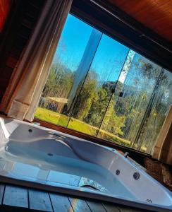 a bath tub sitting in front of a window at Recanto Della Mata in Venda Nova do Imigrante