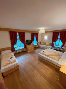 a large room with two beds and windows at Rifugio Ospitale in Cortina dʼAmpezzo +62 photos