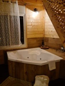 a large white tub in a bathroom with a window at Vida Bhermon 1, one wood Cabin in Majdal Shams