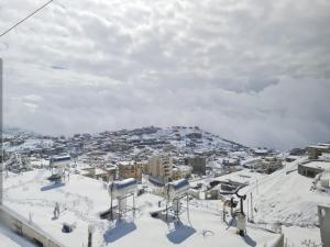 a view of a city covered in snow at וידה בחרמון- סוויטות עץ במג'דל שמס קרוב לחרמון in Majdal Shams
