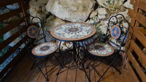 a couple of tables and stools sitting next to a wall at וידה בחרמון- סוויטות עץ במג'דל שמס קרוב לחרמון in Majdal Shams