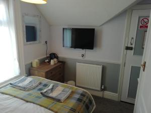 a bedroom with a bed and a flat screen tv at Shirley Heights Hotel in Blackpool