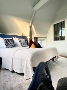 1 dormitorio con 1 cama blanca grande con almohadas en La Maison Gervaiserie & Spa en Réville