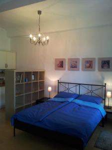 Un dormitorio con una cama azul y una lámpara de araña. en Studio Ian 1, en Liubliana