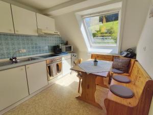 eine kleine Küche mit einem Tisch und einem Fenster in der Unterkunft Pension Zur Rose in Bad Peterstal-Griesbach
