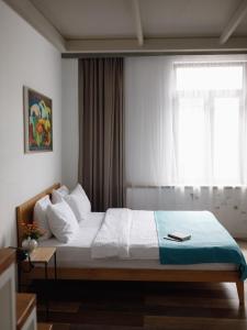 a bedroom with a large bed with a window at Mariinsky Boutique Hotel in Batumi