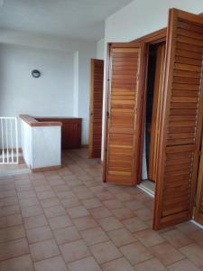 Zimmer mit Holztüren und Fliesenboden in der Unterkunft Casa Antonella Caronia Marina in Caronia Marina