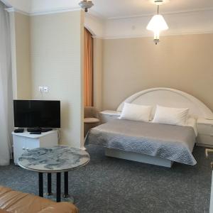 a hotel room with a bed and a flat screen tv at Baza Otdykha Ozero Zerkalnoe in Poselok Zerkalniy