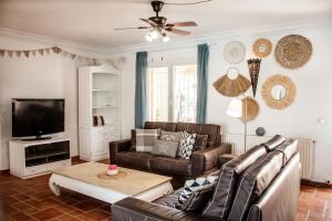 ein Wohnzimmer mit einem Sofa und einem TV in der Unterkunft Villa Las Palmeras with private pool and garden in Altea